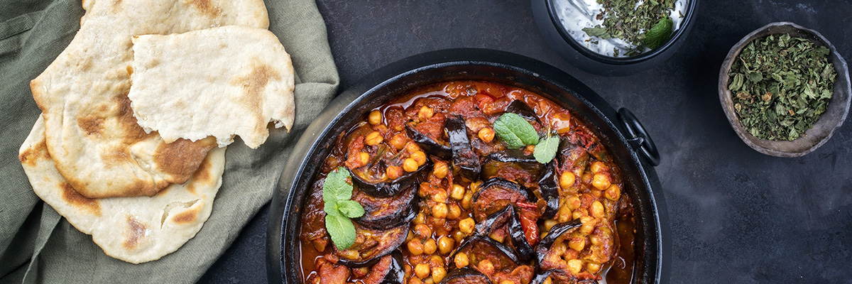 kikherne-munakoisopata naan-leivän kanssa tummalla taustalla